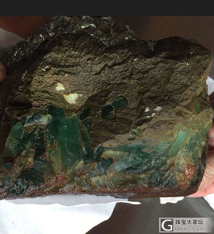 大大们看一下这个是什么矿石
上面有一层亮银色的块块下面
全是绿色柱粘在一起。_玉石
