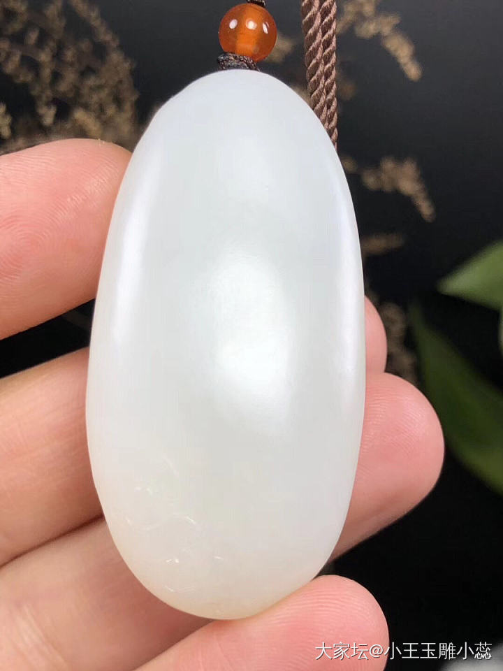 玉白皮且末料,脂白的小佛,油性足,手工雕,背后有几个黑点,结构均匀